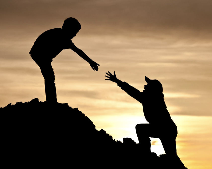 Person helping another up a hill